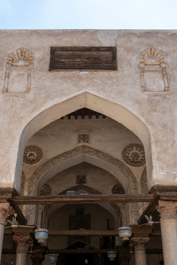View of the intricate arched entrance of the Mosque of al Salih Tala i with stone carvings and hanging lamps Cairo Egypt. View of the intricate arched entrance of the Mosque of al Salih Tala i with stone carvings and hanging lamps Cairo Egypt.