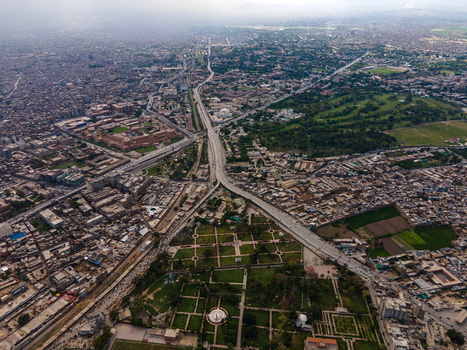 Aerial view of Bala Hisar Fort surrounded by the dense urban sprawl historic architecture and a major highway cutting through the city of Peshawar Khyber Pakhtunkhwa Pakistan.