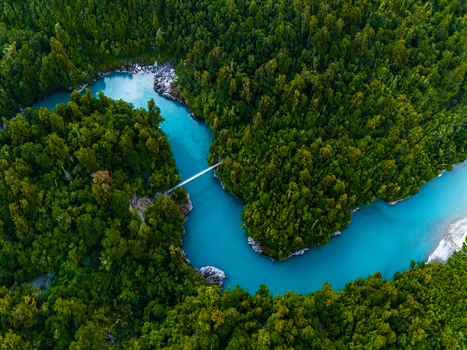 Aerial view of the Hokitika River snaking through verdant forests crossed by a suspended footbridge a symphony of turquoise and emerald hues Hokitika Gorge New Zealand. Aerial view of the Hokitika River snaking through verdant forests crossed by a suspended footbridge a symphony of turquoise and emerald hues Hokitika Gorge New Zealand.