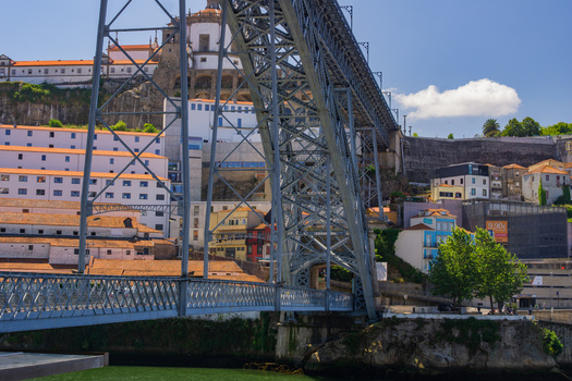 Porto Portugal 13 July 2021 View of the imposing Dom Luís I Bridge its steel structure contrasting against the city s terracotta rooftops and the Douro River s deep green hues. Porto Portugal 13 July 2021 View of the imposing Dom Luís I Bridge its steel structure contrasting against the city s terracotta rooftops and the Douro River s deep green hues.