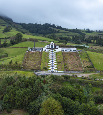 Aerial view of the Chapel of Nossa Senhora da Paz with its iconic staircase surrounded by lush green hills and fields Vila Franca Do Campo Acores Portugal. Aerial view of the Chapel of Nossa Senhora da Paz with its iconic staircase surrounded by lush green hills and fields Vila Franca Do Campo Acores Portugal.