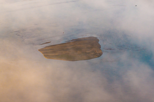 Aerial view of the sandy Zawadowskie Islands Nature Reserve in the Vistula River surrounded by morning mist in Warsaw Masovian Voivodeship Poland.