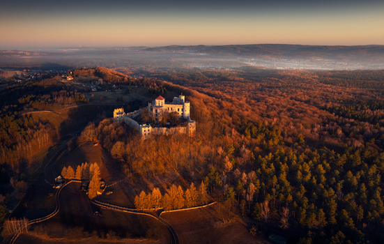 Aerial view of Tenczyn Castle ruins on a forested hill during a golden hour sunset in Krakow County Lesser Poland Voivodeship Poland. Aerial view of Tenczyn Castle ruins on a forested hill during a golden hour sunset in Krakow County Lesser Poland Voivodeship Poland.