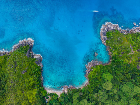 Aerial view of the turquoise sea meeting the verdant coastline with rocky outcrops and dense tropical foliage Montagne Jasmin Mahe Island Seychelles. Aerial view of the turquoise sea meeting the verdant coastline with rocky outcrops and dense tropical foliage Montagne Jasmin Mahe Island Seychelles.