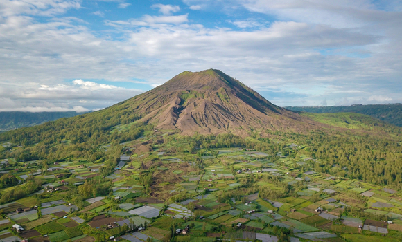 Aerial view of mount Batur on a bright cloudy day overlooking Pinggan village in north Bali Indonesia.