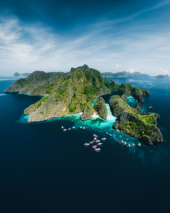 Aerial view of Big Lagoon with limestone cliffs turquoise waters and outrigger boats in El Nido Bay Philippines. Aerial view of Big Lagoon with limestone cliffs turquoise waters and outrigger boats in El Nido Bay Philippines.