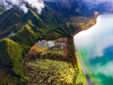 Aerial view of Lagoa do Fogo crater lake surrounded by lush green volcanic ridges and soft white clouds Agua de Alto Azores Portugal. Aerial view of Lagoa do Fogo crater lake surrounded by lush green volcanic ridges and soft white clouds Agua de Alto Azores Portugal.