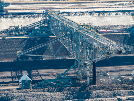 Aerial view of the Tagebau Welzow Sud brown coal open pit mine featuring a massive bucket wheel excavator extracting coal from deep earth layers in Spremberg Brandenburg Germany. Aerial view of the Tagebau Welzow Sud brown coal open pit mine featuring a massive bucket wheel excavator extracting coal from deep earth layers in Spremberg Brandenburg Germany.