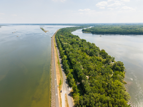 Aerial view of the Danube river bank with a long cycling path and lush green forest under a clear sky in Bratislava Bratislava Region Slovakia. Aerial view of the Danube river bank with a long cycling path and lush green forest under a clear sky in Bratislava Bratislava Region Slovakia.