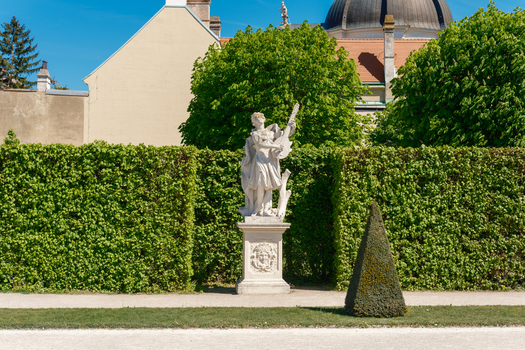 View of a classical marble statue playing a lute in the manicured gardens of the Belvedere Palace under a clear blue sky in Vienna Vienna Austria. View of a classical marble statue playing a lute in the manicured gardens of the Belvedere Palace under a clear blue sky in Vienna Vienna Austria.