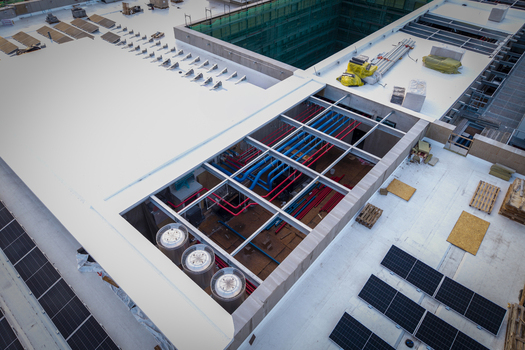 Aerial view of the ai data center cooling system featuring complex red and blue piping industrial fans and solar panels installed on a flat rooftop in Krakow Lesser Poland Voivode Poland. Aerial view of the ai data center cooling system featuring complex red and blue piping industrial fans and solar panels installed on a flat rooftop in Krakow Lesser Poland Voivode Poland.
