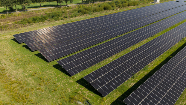 Aerial view of Zonnepark Pekela featuring rows of solar panels installed on green grass fields in Oude Pekela Groningen Netherlands. Aerial view of Zonnepark Pekela featuring rows of solar panels installed on green grass fields in Oude Pekela Groningen Netherlands.