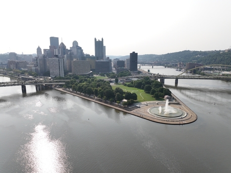 Aerial view of the Point State Park Fountain at the river confluence with the Pittsburgh skyline green parkland and bridges in Pittsburgh Pennsylvania United States.