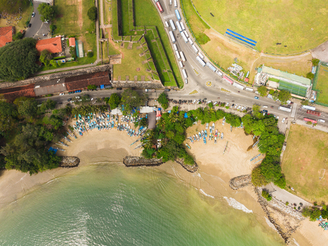 Aerial view of Galle Fort historic walls and colorful fishing boats lined up on the sandy beach with a busy road and lush greenery in Galle Southern Province Sri Lanka. Aerial view of Galle Fort historic walls and colorful fishing boats lined up on the sandy beach with a busy road and lush greenery in Galle Southern Province Sri Lanka.