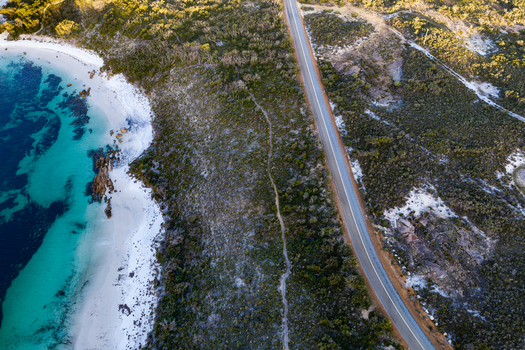 Aerial view of Camp Quaranup featuring turquoise waters white sandy beach rocky coastline and a coastal road in Vancouver Peninsula Western Australia Australia. Aerial view of Camp Quaranup featuring turquoise waters white sandy beach rocky coastline and a coastal road in Vancouver Peninsula Western Australia Australia.