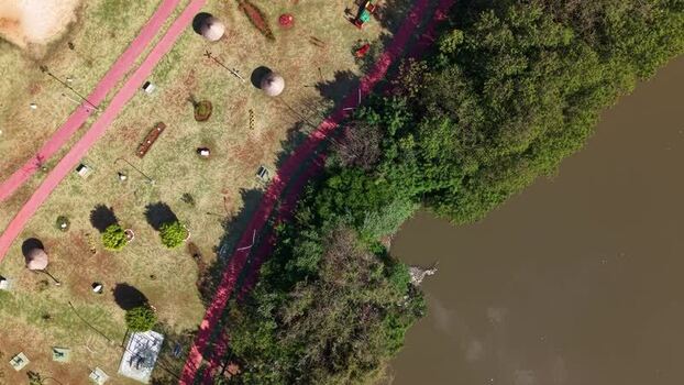 Aerial view of a park with a red path and trees in Brazil.