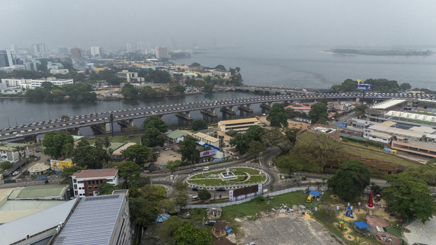 Aerial view of Lagos Island featuring the bridge over the lagoon urban infrastructure green spaces and surrounding city buildings in Lagos Lagos Nigeria. Aerial view of Lagos Island featuring the bridge over the lagoon urban infrastructure green spaces and surrounding city buildings in Lagos Lagos Nigeria.