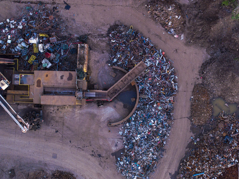 Aerial view of a scrap metal recycling facility with large piles of sorted metal industrial machinery and a conveyor belt in Charleroi Wallonia Belgium.