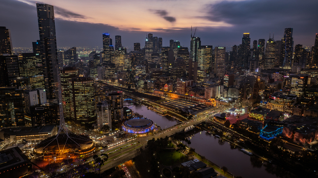 Aerial view of the Melbourne skyline at dusk featuring the Yarra River the illuminated Arts Centre spire and the historic Flinders Street Station in Southbank Victoria Australia. Aerial view of the Melbourne skyline at dusk featuring the Yarra River the illuminated Arts Centre spire and the historic Flinders Street Station in Southbank Victoria Australia.