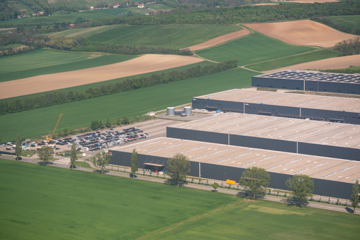 Enzersdorf an der Fischa Austria 24 April 2026 Aerial view of Industrial Campus Vienna East featuring large modern warehouses and a parking lot surrounded by green agricultural fields. Enzersdorf an der Fischa Austria 24 April 2026 Aerial view of Industrial Campus Vienna East featuring large modern warehouses and a parking lot surrounded by green agricultural fields.