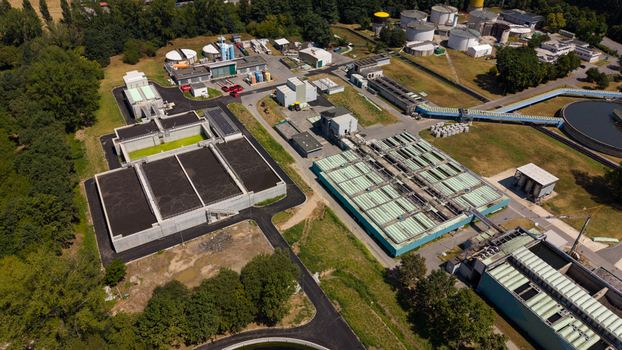 Aerial view of a modern water treatment plant featuring large sedimentation tanks filtration basins and industrial infrastructure in Milan Lombardy Italy. Aerial view of a modern water treatment plant featuring large sedimentation tanks filtration basins and industrial infrastructure in Milan Lombardy Italy.
