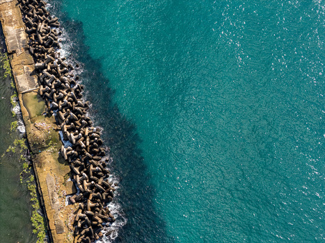 Aerial view of the Rio Ozama coastline featuring concrete tetrapods along the breakwater and clear turquoise water in Santo Domingo Santo Domingo Dominican Republic.