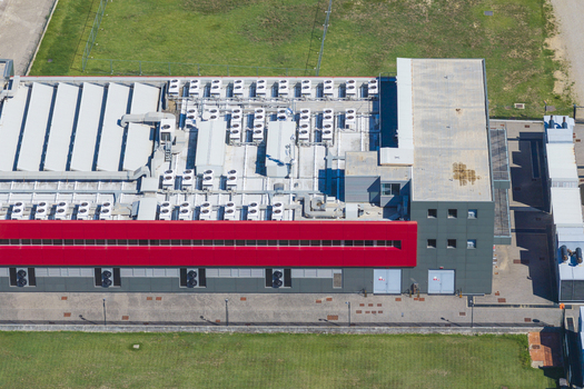 Aerial view of a modern datacenter building with rows of HVAC units on the roof a red facade and grey walls located in Arezzo Tuscany Italy. Aerial view of a modern datacenter building with rows of HVAC units on the roof a red facade and grey walls located in Arezzo Tuscany Italy.