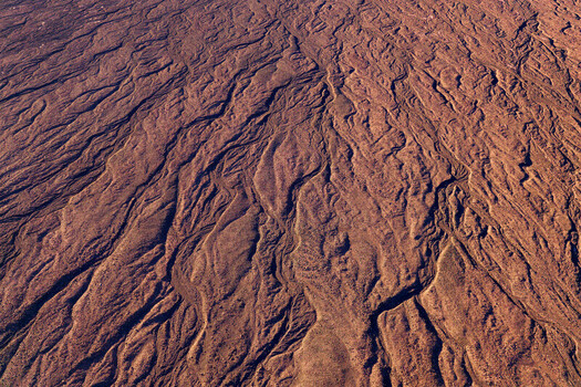 Aerial view of the Atacama Desert showing intricate erosion patterns and dry riverbeds across the arid landscape in Antofagasta Chile.