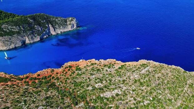 Aerial view of blue sea bay with rocky cliffs and boats Greece.