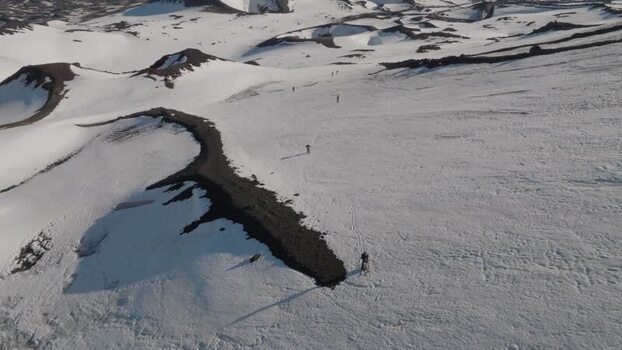 Aerial view of hikers trekking on the snowy slopes of Mount Etna Italy. Aerial view of hikers trekking on the snowy slopes of Mount Etna Italy.