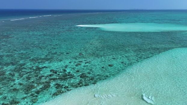 Aerial view of turquoise waters and coral reefs near a sandbar Maldives. Aerial view of turquoise waters and coral reefs near a sandbar Maldives.