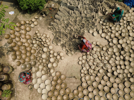 Joypurhat Bangladesh 28 September 2026 Aerial view of artisans arranging clay bowls on the ground to dry showcasing traditional pottery craftsmanship. Joypurhat Bangladesh 28 September 2026 Aerial view of artisans arranging clay bowls on the ground to dry showcasing traditional pottery craftsmanship.