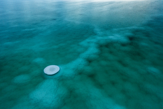 Aerial view of the Dead Sea s turquoise waters swirl around a solitary circular structure creating a mesmerizing contrast of textures and tones Israel. Aerial view of the Dead Sea s turquoise waters swirl around a solitary circular structure creating a mesmerizing contrast of textures and tones Israel.
