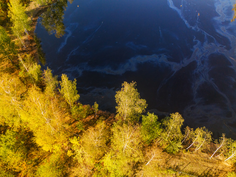 Aerial view of the acid tar lagoons surrounded by vibrant autumn trees in Predajna Banskobystricky kraj Slovakia. Aerial view of the acid tar lagoons surrounded by vibrant autumn trees in Predajna Banskobystricky kraj Slovakia.