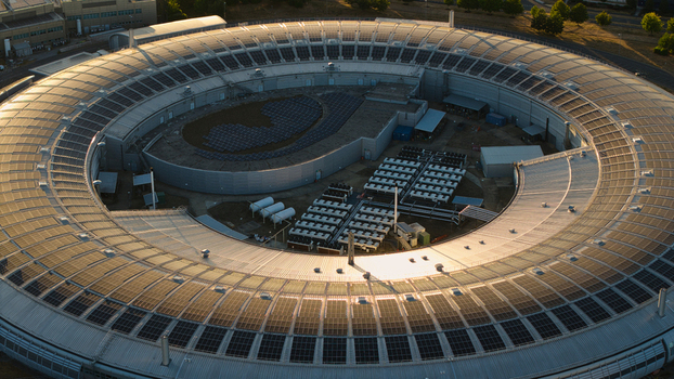 Aerial view of Diamond Light Source a circular synchrotron facility surrounded by greenery under golden hour light in Didcot United Kingdom.