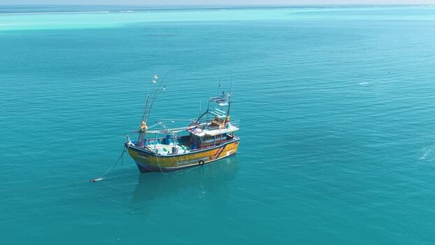 Aerial view of a fishing boat in turquoise waters Maldives. Aerial view of a fishing boat in turquoise waters Maldives.