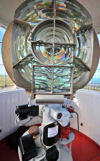 View of the intricate Fresnel lens and rotating mechanism inside the lighthouse lantern room at Puerto Piramides Puerto Madryn Chubut Argentina. View of the intricate Fresnel lens and rotating mechanism inside the lighthouse lantern room at Puerto Piramides Puerto Madryn Chubut Argentina.