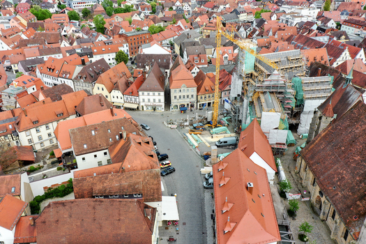 Aerial view of Rathaus Forchheim under renovation with scaffolding and a construction crane among historic red tiled rooftops in Forchheim Bayern Germany.