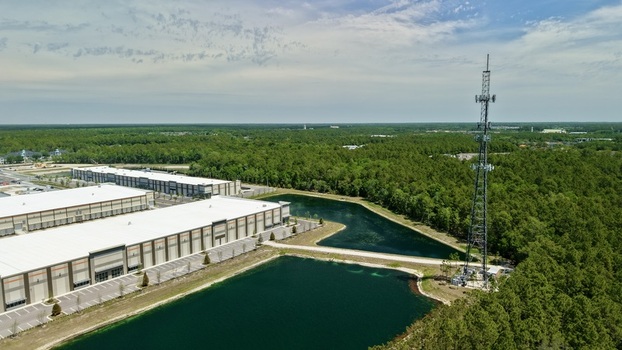 Aerial view of industrial warehouses and a tall telecommunications tower near retention ponds and dense green forest at World Golf Village Florida United States. Aerial view of industrial warehouses and a tall telecommunications tower near retention ponds and dense green forest at World Golf Village Florida United States.