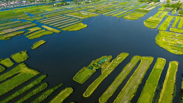 Aerial view of Oosterdel nature reserve featuring unique small islands and water channels under bright sunlight in Broek op Langedijk Noord Holland Netherlands. Aerial view of Oosterdel nature reserve featuring unique small islands and water channels under bright sunlight in Broek op Langedijk Noord Holland Netherlands.