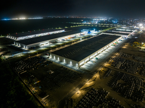 Aerial view of the illuminated Caucedo Logistics Center at night with large warehouses rows of parked vehicles and infrastructure in Andres Santo Domingo Dominican Republic. Aerial view of the illuminated Caucedo Logistics Center at night with large warehouses rows of parked vehicles and infrastructure in Andres Santo Domingo Dominican Republic.