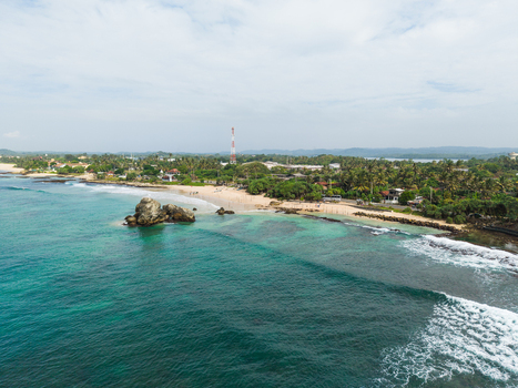 Aerial view of the tropical coastline with turquoise waters a sandy beach and lush palm trees Koggala Southern Province Sri Lanka. Aerial view of the tropical coastline with turquoise waters a sandy beach and lush palm trees Koggala Southern Province Sri Lanka.