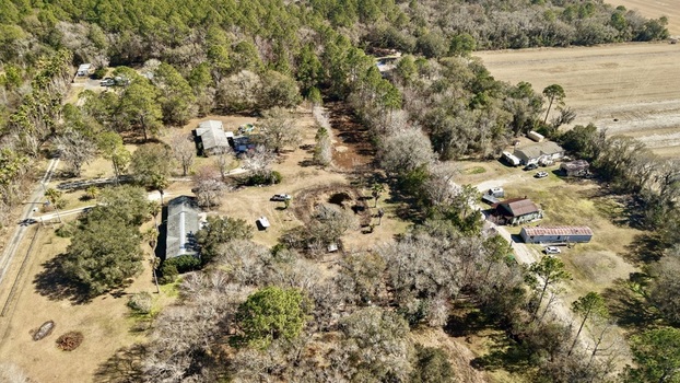 Aerial view of a rural landscape reveals homes nestled among trees with fields stretching out under the clear sky Elkton Florida United States. Aerial view of a rural landscape reveals homes nestled among trees with fields stretching out under the clear sky Elkton Florida United States.