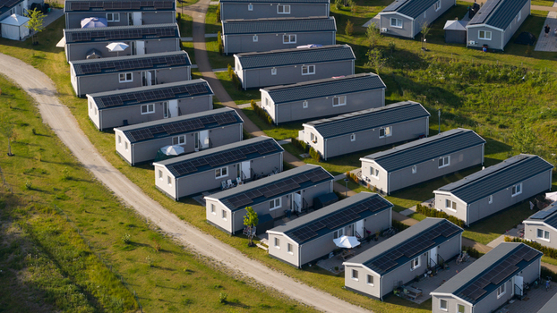 Aerial view of rows of modern grey residential units with solar panels on their roofs situated in a green park like setting in Venlo Limburg Netherlands. Aerial view of rows of modern grey residential units with solar panels on their roofs situated in a green park like setting in Venlo Limburg Netherlands.
