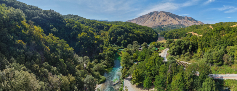 Aerial view of The Blue Eye spring with its vibrant turquoise water surrounded by lush green forest and mountains in Saranda Qarku i Vlores Albania. Aerial view of The Blue Eye spring with its vibrant turquoise water surrounded by lush green forest and mountains in Saranda Qarku i Vlores Albania.
