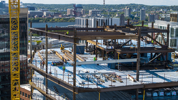 Aerial view of the construction site at Kendall Square featuring steel framework and workers in Cambridge Massachusetts United States. Aerial view of the construction site at Kendall Square featuring steel framework and workers in Cambridge Massachusetts United States.