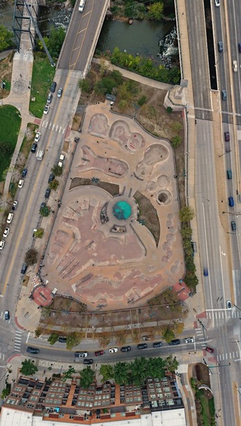 Aerial view of the Denver Skatepark featuring concrete bowls ramps and paths surrounded by urban roads and bridges in Denver Colorado United States. Aerial view of the Denver Skatepark featuring concrete bowls ramps and paths surrounded by urban roads and bridges in Denver Colorado United States.