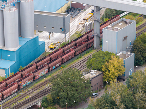 Aerial view of the Heizkraftwerk Reuter West power plant featuring industrial infrastructure freight trains on tracks storage silos and surrounding greenery. Berlin Berlin Germany.
