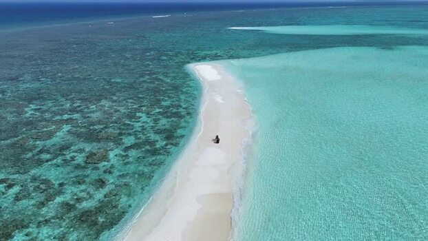 Aerial view of a person sitting on a white sandbank Maldives. Aerial view of a person sitting on a white sandbank Maldives.