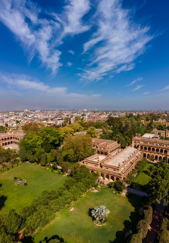 Aerial view of Islamia College University Peshawar featuring historic brick architecture lush green lawns and trees under a clear blue sky in Peshawar Khyber Pakhtunkhwa Pakistan. Aerial view of Islamia College University Peshawar featuring historic brick architecture lush green lawns and trees under a clear blue sky in Peshawar Khyber Pakhtunkhwa Pakistan.